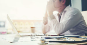 burned out doctor at laptop computer
