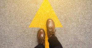 feet moving along an arrow on the ground